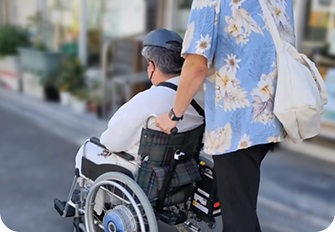 男性が車いすを押して介護をしている様子