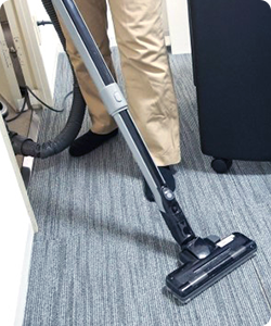 スタッフが掃除機をかけている様子